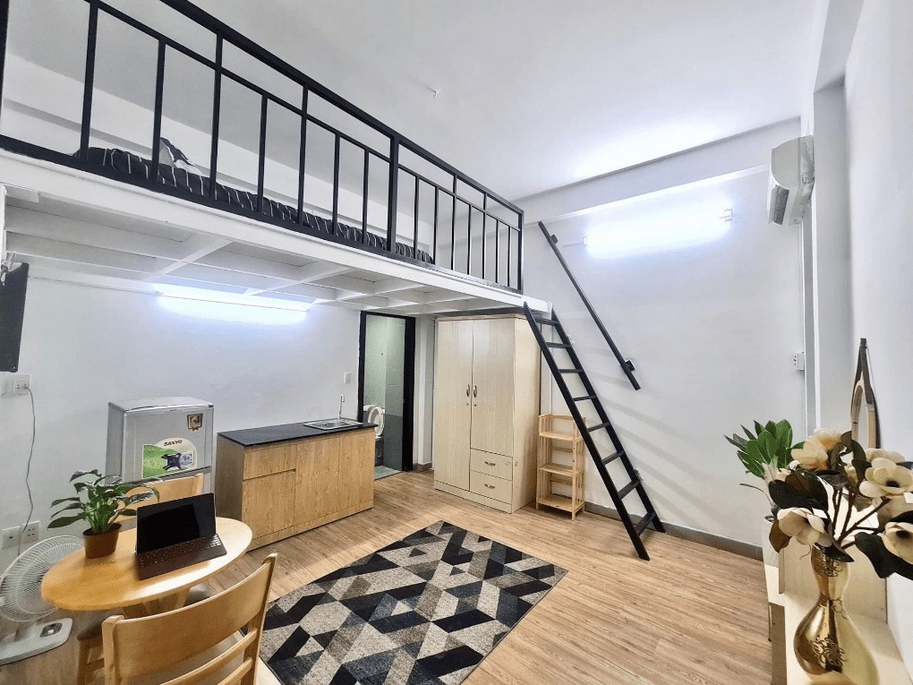 nhung-luu-y-khi-bat-dau-xay-dung-phong-tro-20m2 Phòng trọ hiện đại với gác lửng, nội thất gỗ, bàn làm việc, tủ lạnh, và thang lên gác.
