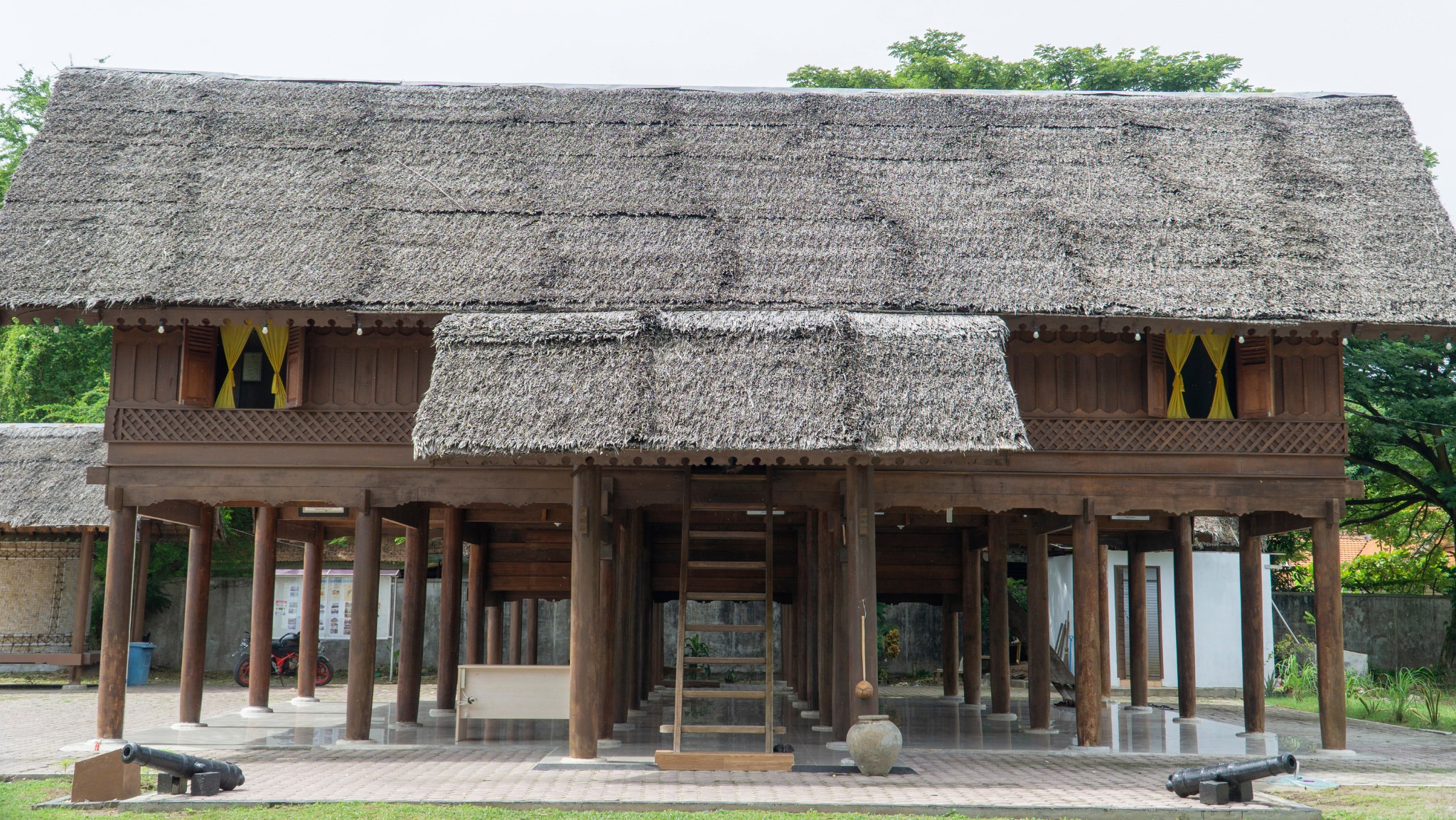 Ngôi nhà truyền thống với mái lá và cột gỗ tại một làng cổ, mang kiến trúc độc đáo và bản sắc văn hóa.