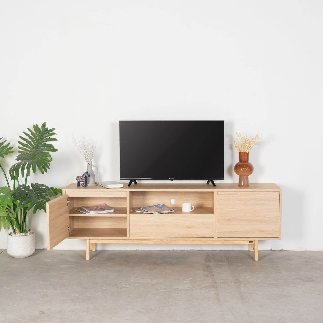 Kệ tivi gỗ hiện đại, trang trí cây xanh và đồ nội thất, phong cách tối giản phòng khách.