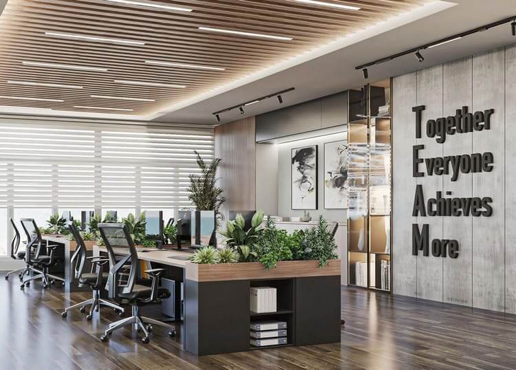 Văn phòng hiện đại với cây xanh, bàn làm việc chung, slogan “TEAM” trên tường, ánh sáng tự nhiên từ cửa sổ.
