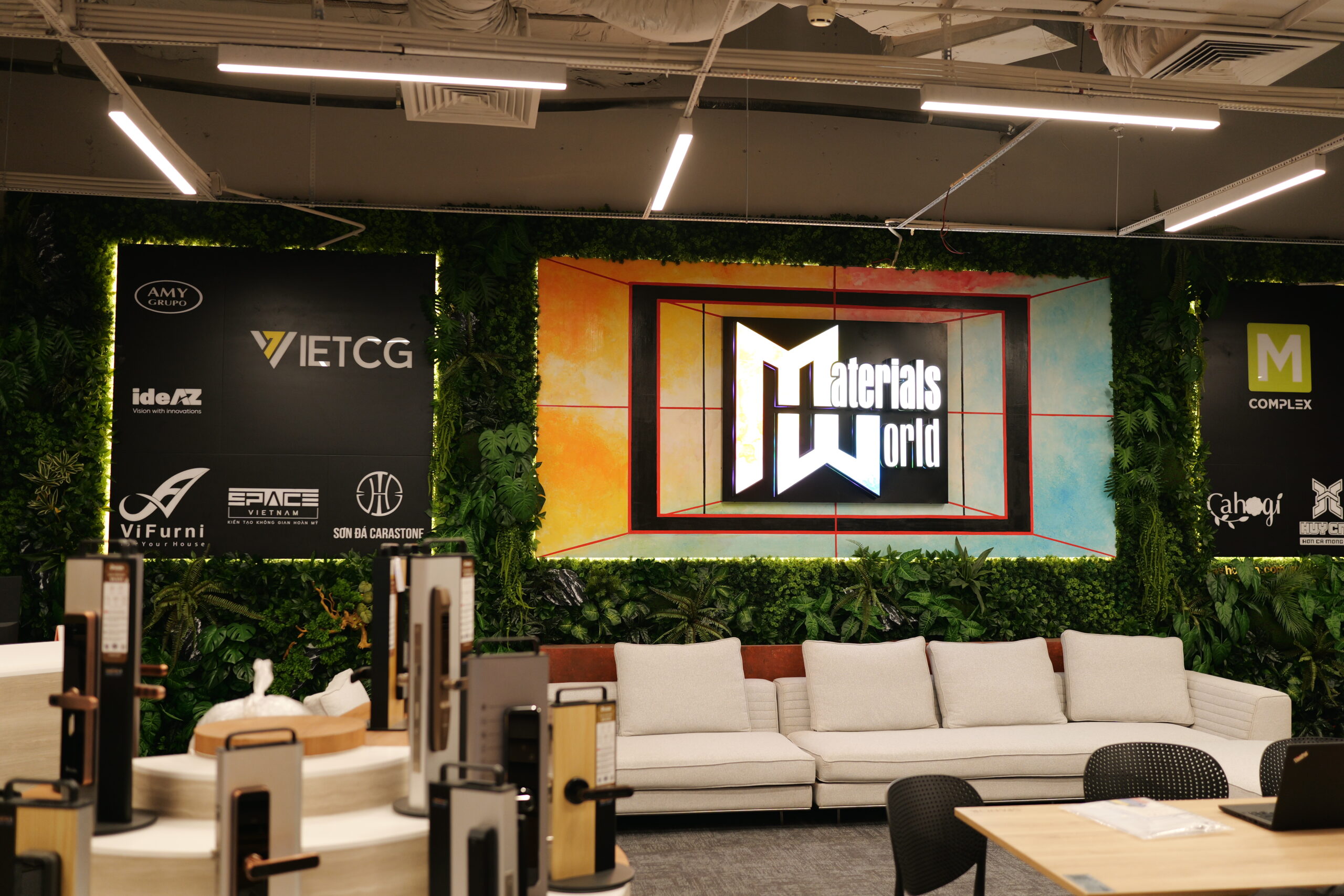 Phòng trưng bày nội thất với bảng hiệu Materials World, nội thất hiện đại và cây xanh trang trí.
