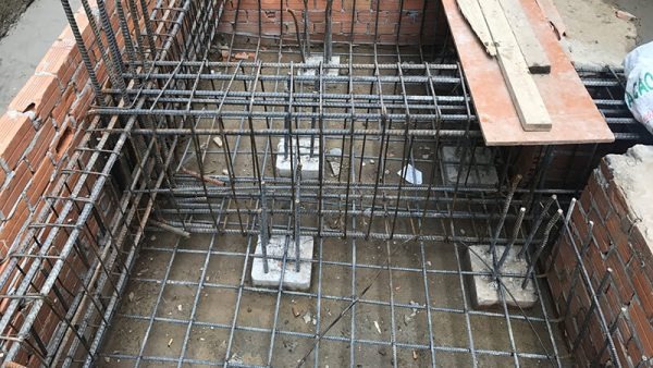 phan-loai-mong-bang-2-phuong Khung thép xây dựng sàn bê tông với tường gạch xung quanh, chuẩn bị cho công đoạn đổ bê tông.