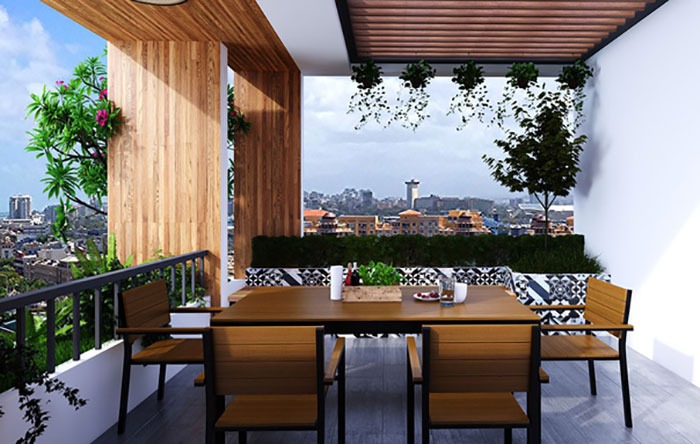 Ban công với bàn ghế gỗ nhìn ra thành phố, trang trí cây xanh tạo không gian thư giãn và phong cảnh đẹp.