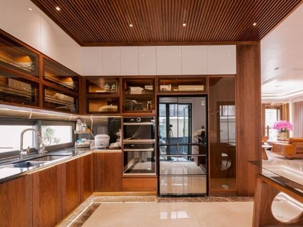 Nhà bếp hiện đại với tủ gỗ và thiết bị inox, không gian rộng rãi và thoáng đãng.