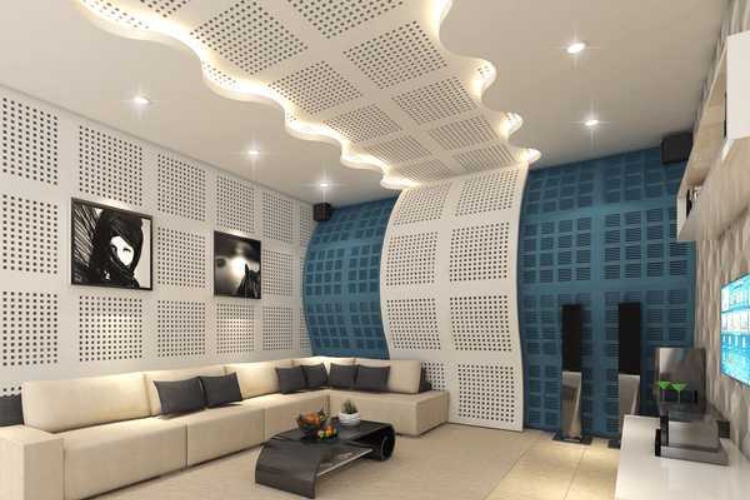 phong-cach-am-la-gi Phòng khách hiện đại với sofa, tường cách âm kiểu dáng nghệ thuật và hệ thống âm thanh.