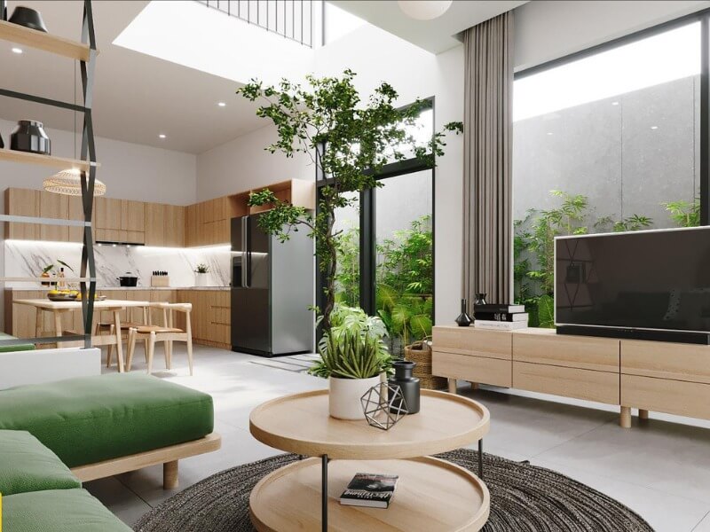 Phòng khách hiện đại với cây xanh, nội thất gỗ, ánh sáng tự nhiên, và bếp mở.