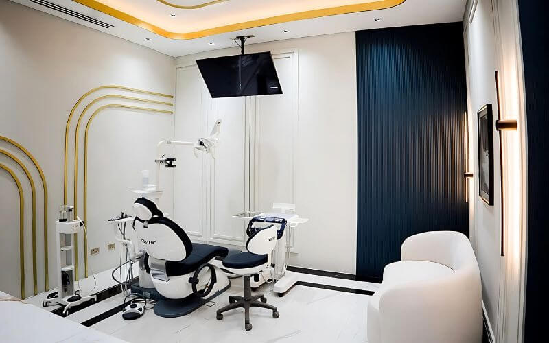 Phòng khám nha khoa hiện đại với ghế nha khoa, màn hình và thiết kế nội thất tinh tế.