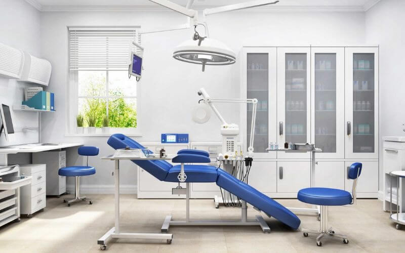 Phòng khám nha khoa hiện đại với thiết bị tiên tiến và ghế điều trị màu xanh dương.