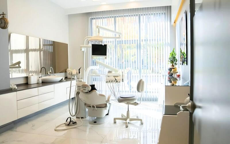 Phòng khám nha khoa hiện đại với ghế nha và thiết bị tiên tiến, bầu không khí sáng và thoáng đãng.