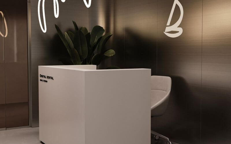 Quầy lễ tân hiện đại với ghế trắng và cây xanh, phù hợp không gian công ty hoặc văn phòng.