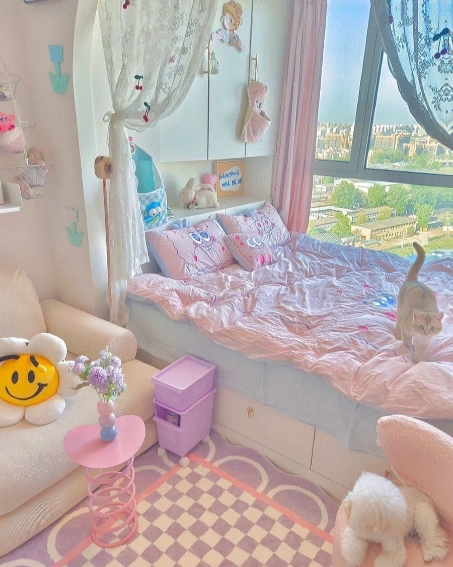 Phòng ngủ dễ thương với chăn màu hồng, mèo, và cảnh ngoài trời qua cửa sổ lớn.
