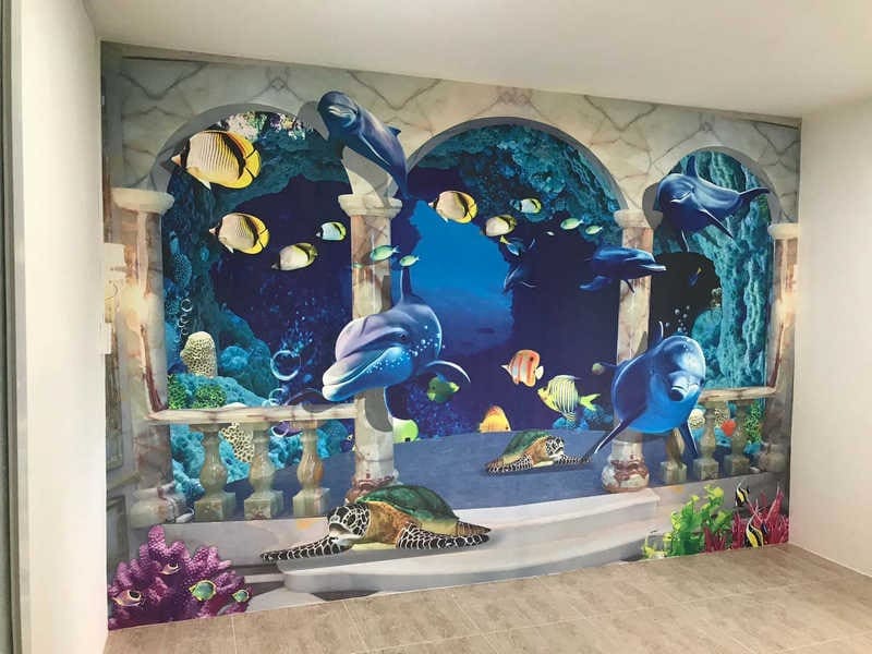 phong-ngu-hoat-hinh-4 Bức tranh 3D đại dương với cá heo, rùa và cá trên tường, tạo không gian sống động và thú vị cho căn phòng.