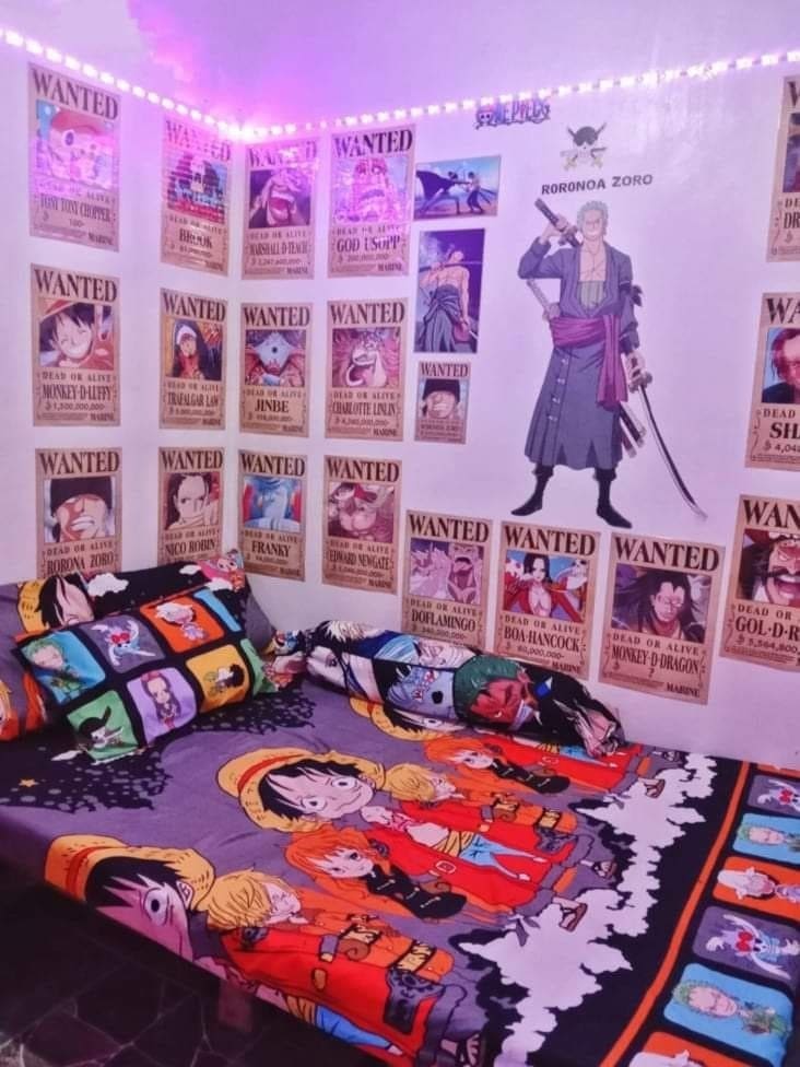 Phòng ngủ trang trí chủ đề One Piece với poster và chăn ga giường in hình nhân vật anime nổi tiếng.