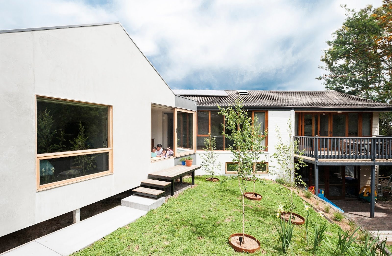 phong-thuy-nha-anh-huong-den-van-menh Ngôi nhà hiện đại với sân vườn xanh mát, cửa sổ lớn, bầu trời trong xanh.