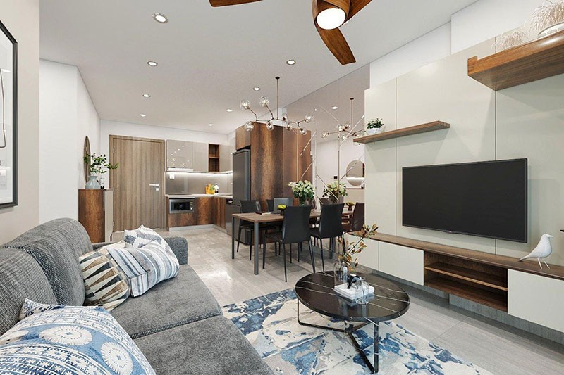 phong-thuy-nha-tac-dong-den-tai-loc Phòng khách hiện đại với ghế sofa màu xám, bàn tròn, và tủ TV, bên cạnh bếp và bàn ăn sang trọng.