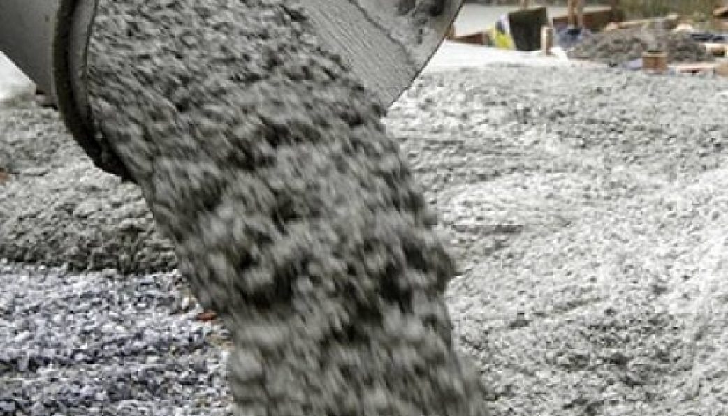 Bê tông đang được đổ từ xe trộn bê tông tại một khu công trình xây dựng.