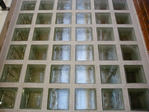 Sàn gạch kính vuông, phản chiếu ánh sáng, tạo không gian hiện đại và sáng sủa.