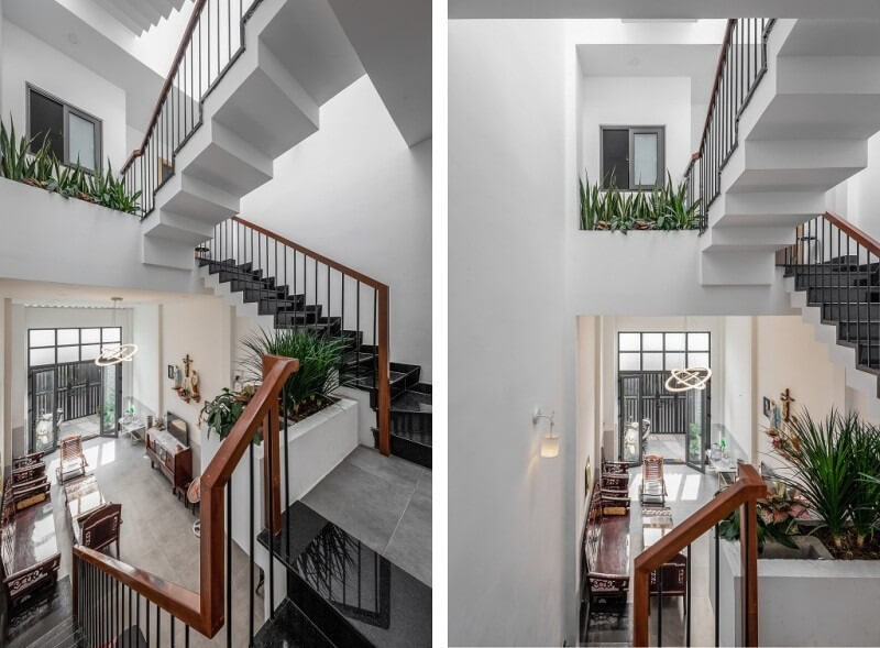 Cầu thang hiện đại với lan can gỗ và cây xanh trong nhà, tạo không gian rộng rãi và sáng sủa.