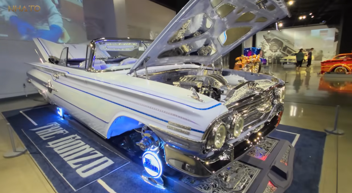 screenshot-2025-07-08-154220 Xe cổ điển tùy chỉnh màu trắng xanh với động cơ được trang trí tại triển lãm ô tô.