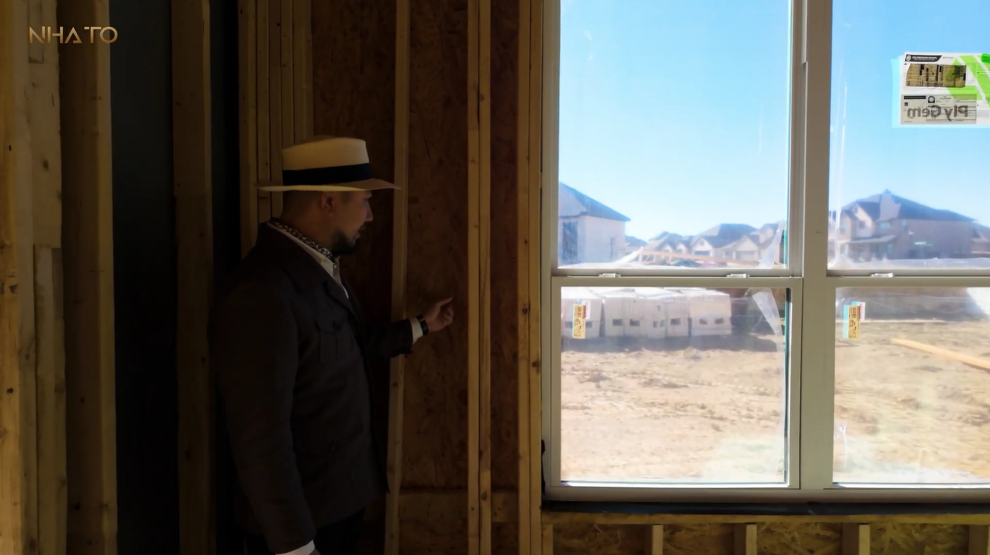 Người đàn ông đội mũ kiểm tra khung cửa sổ trong công trình xây dựng nhà ở.