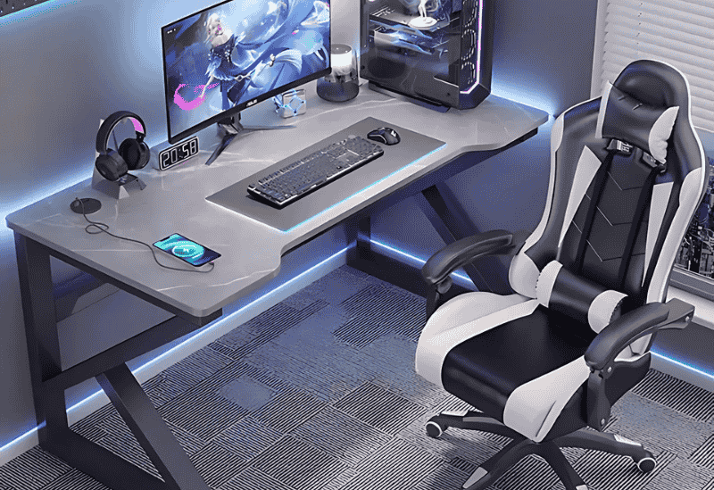 Bàn máy tính hiện đại với ghế game, tai nghe và màn hình hiển thị trò chơi.