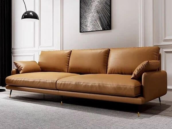 Sofa da màu nâu sang trọng trong phòng khách hiện đại, nổi bật với thiết kế tối giản và đèn trần đen.