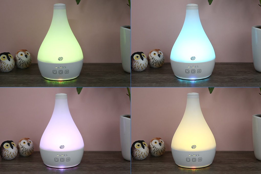 Máy khuếch tán tinh dầu bốn màu: xanh lá, xanh dương, tím, vàng, bên lọ hoa và mô hình cú.