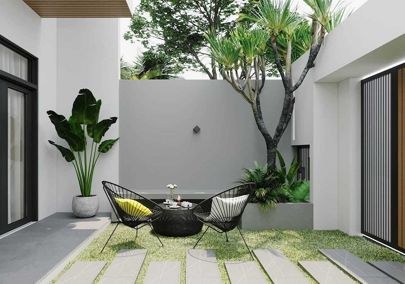 Sân vườn hiện đại với bàn ghế ngoài trời và cây xanh, tạo không gian thư giãn thoáng đãng.