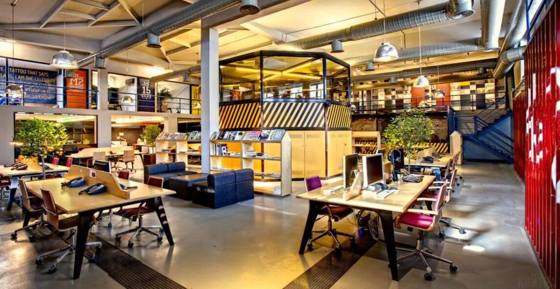 Văn phòng hiện đại với nội thất mở, bàn làm việc xếp gọn và cây xanh trang trí tạo không gian làm việc sáng tạo.