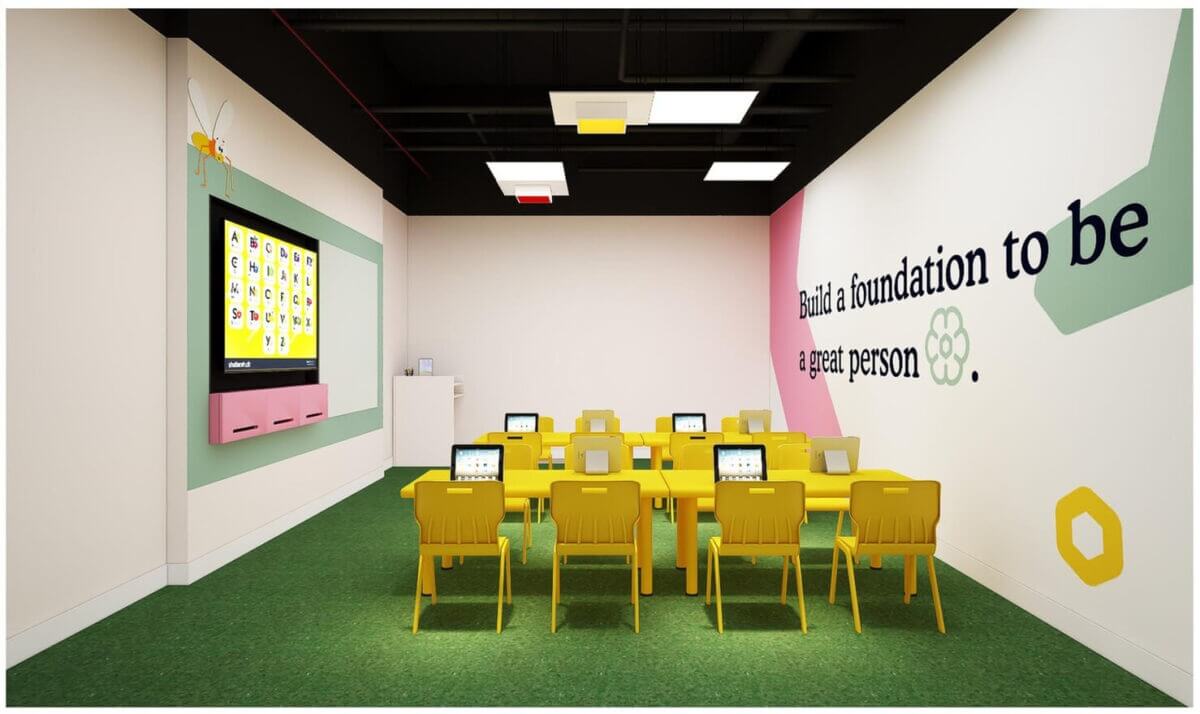 Phòng học hiện đại với bàn ghế vàng, bảng điện tử và câu quote trên tường. Nội thất sáng tạo và thân thiện.