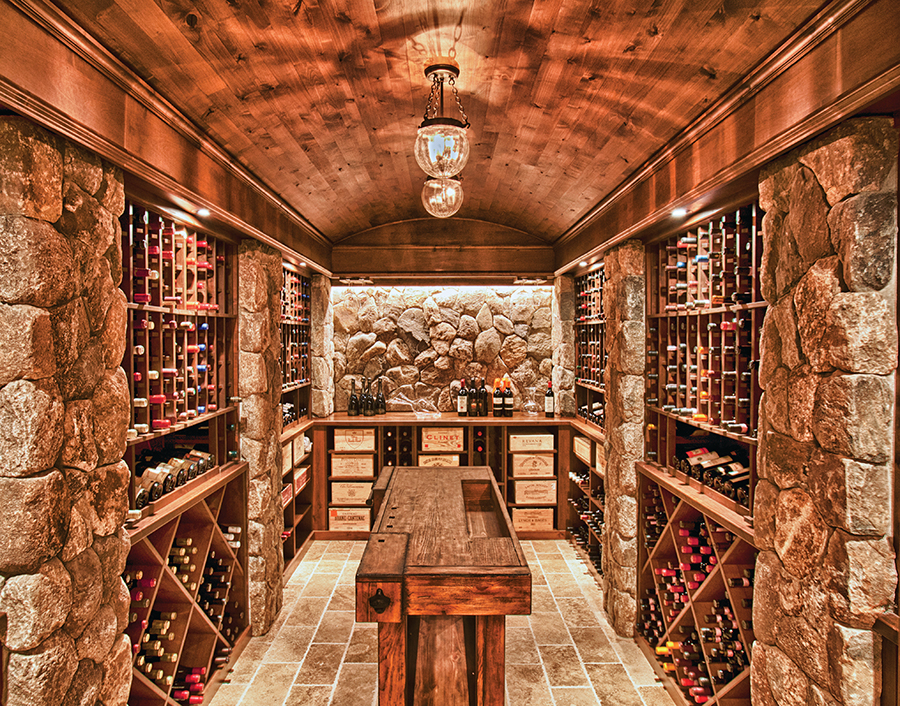 Hầm rượu vang đầy tinh tế với kệ đá và gỗ, chứa nhiều chai rượu được sắp xếp gọn gàng.