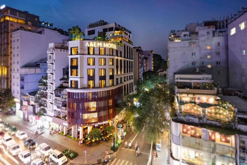Khách sạn A&EM tại góc phố nhộn nhịp, tòa nhà hiện đại giữa khung cảnh đô thị lung linh về đêm.