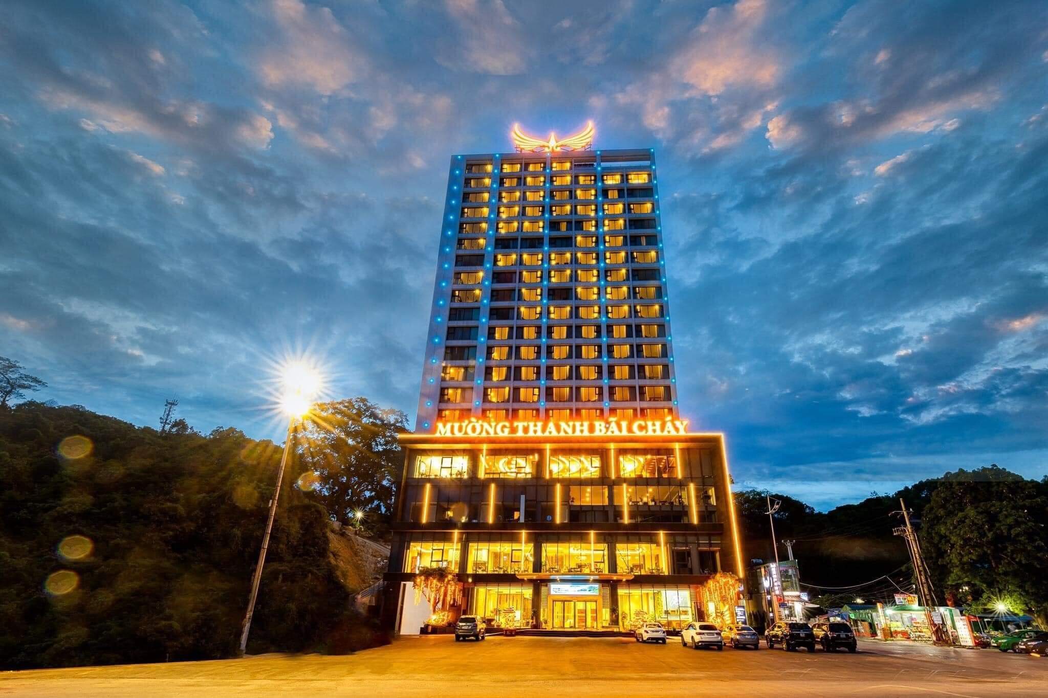 Khách sạn Mường Thanh Bãi Cháy lung linh về đêm với bầu trời xanh mây, ánh đèn nổi bật và tòa nhà cao tầng.
