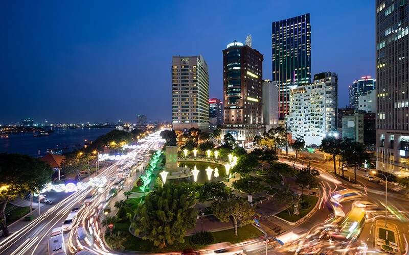 Đường phố Sài Gòn nhộn nhịp về đêm với ánh sáng đô thị và xe cộ di chuyển.