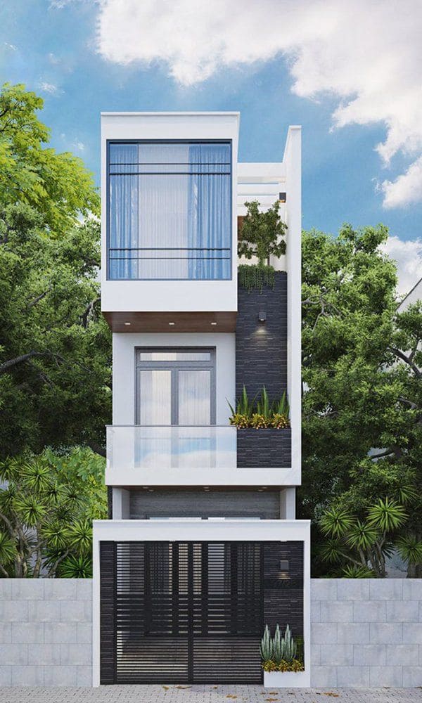 Nhà phố ba tầng hiện đại với cửa kính lớn và cây xanh xung quanh, bầu trời trong xanh.