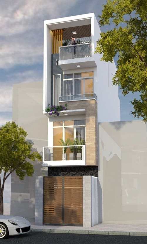 Nhà phố hiện đại ba tầng với ban công cây xanh, cây lớn bên đường, xe hơi đậu phía trước.