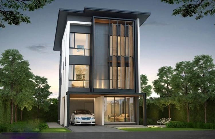 Ngôi nhà hiện đại ba tầng với xe ô tô đỗ trước, bao quanh bởi cây xanh, thiết kế sang trọng và cửa kính lớn.
