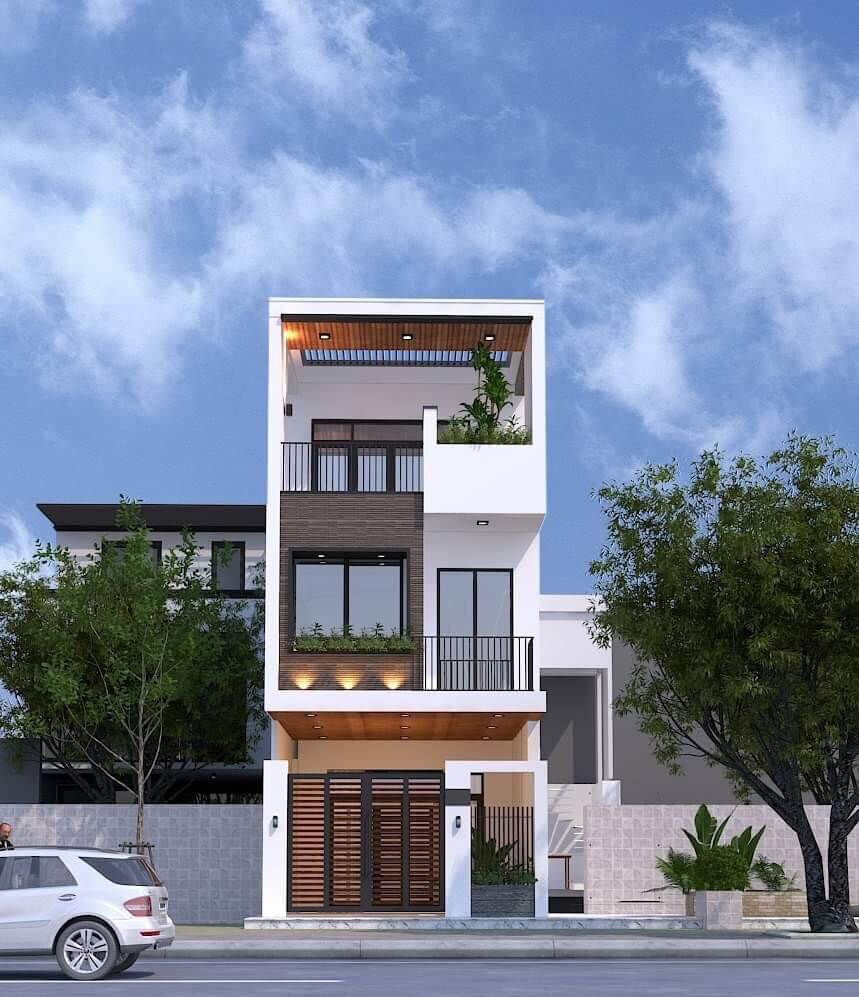 Nhà phố 3 tầng hiện đại với cửa kính lớn, ban công cây xanh, và bầu trời trong xanh.
