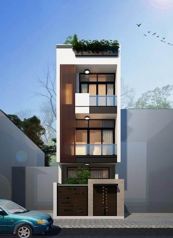 Nhà phố hiện đại ba tầng với ban công kính và cây xanh trên sân thượng, ô tô đỗ trước cửa.