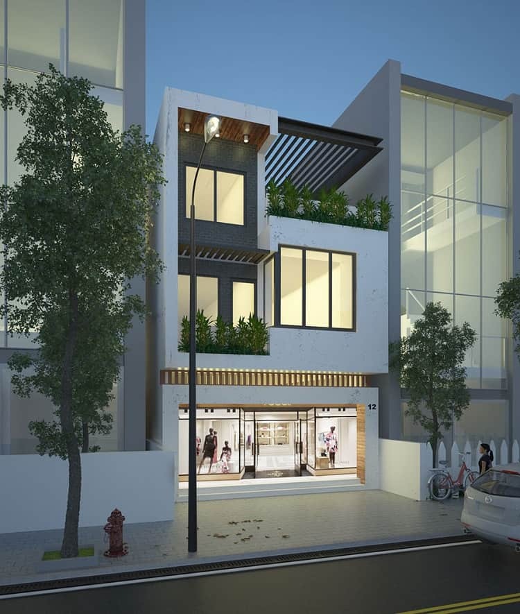 Nhà phố hiện đại ba tầng với cửa kính, ban công nhiều cây xanh, góc phố có đèn đường buổi tối.