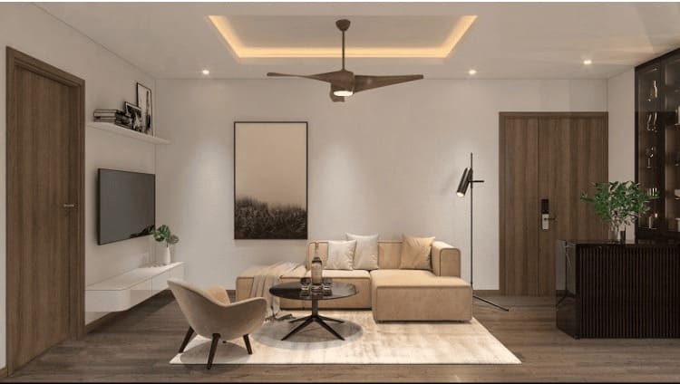 Phòng khách hiện đại với sofa màu kem, quạt trần, tranh treo tường và đèn đọc sách tạo không gian ấm cúng.