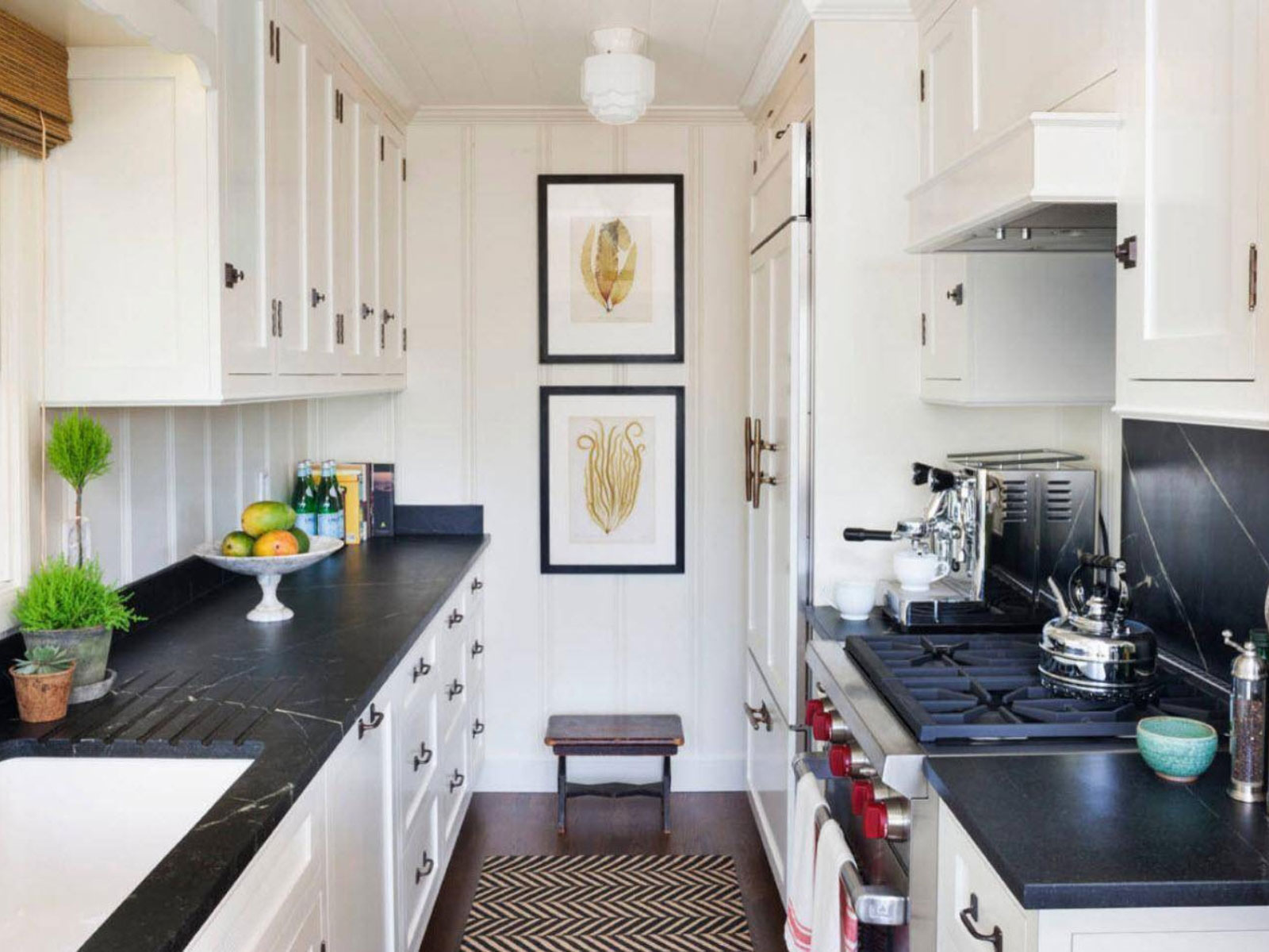 thiet-ke-noi-that-phong-bep-nha-ong-1 Nhà bếp phong cách tối giản với quầy đen, tủ trắng và thiết bị nấu ăn hiện đại.