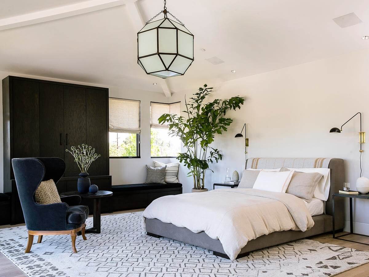 thiet-ke-noi-that-phong-ngu-12m2-phong-cach-hien-dai-3 Phòng ngủ hiện đại với giường, ghế bành, ánh sáng tự nhiên và cây xanh, tạo cảm giác thoải mái và sang trọng.