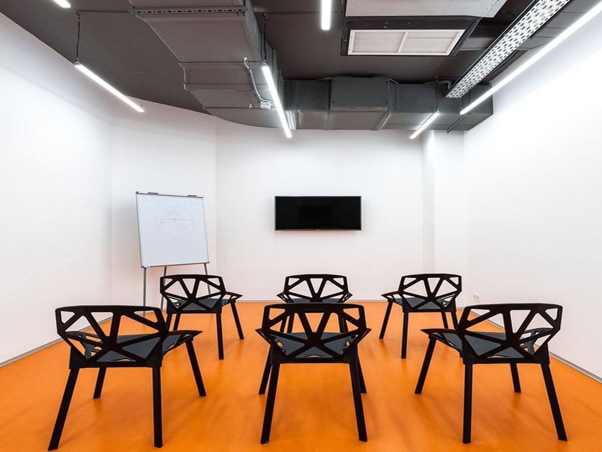 Phòng hội thảo hiện đại với sàn cam, ghế thiết kế độc đáo và bảng trắng.