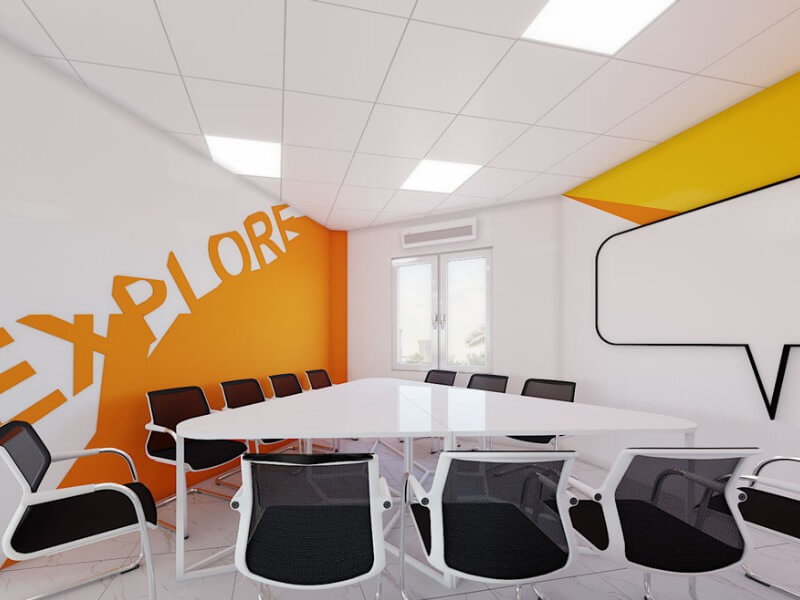 Phòng họp hiện đại với bàn trắng hình chữ U, tường có chữ Explore, ánh sáng tự nhiên từ cửa sổ.