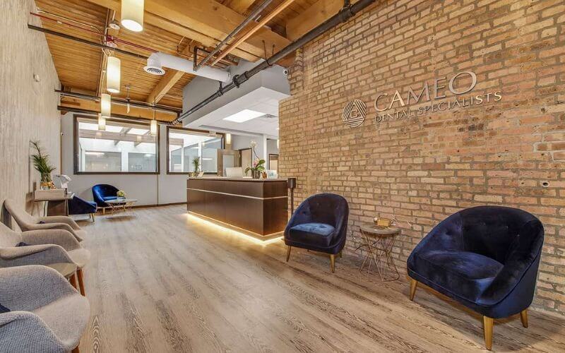 Phòng chờ văn phòng nha khoa hiện đại với tường gạch và nội thất sang trọng.