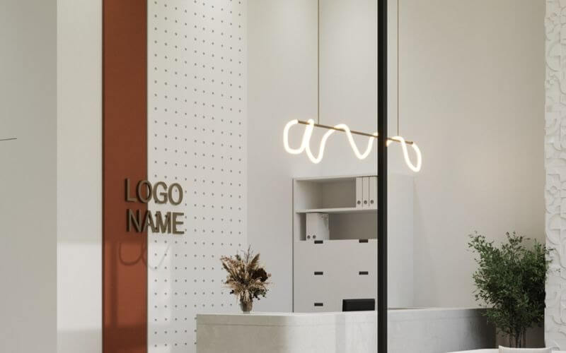 Văn phòng hiện đại với nội thất tối giản, bàn lễ tân trắng, đèn thiết kế độc đáo và cây trang trí xanh tươi.