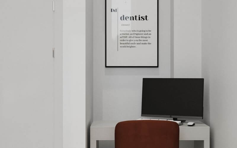 Góc làm việc tối giản với máy tính và tranh nghệ thuật treo tường, tạo không gian làm việc thoải mái.