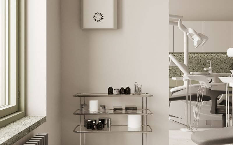 Phòng khám nha khoa hiện đại với ghế điều trị và kệ đựng dụng cụ, ánh sáng tự nhiên từ cửa sổ lớn.