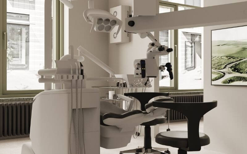 Phòng khám nha khoa hiện đại với ghế và dụng cụ nha khoa tiên tiến, ánh sáng tự nhiên từ cửa sổ lớn.